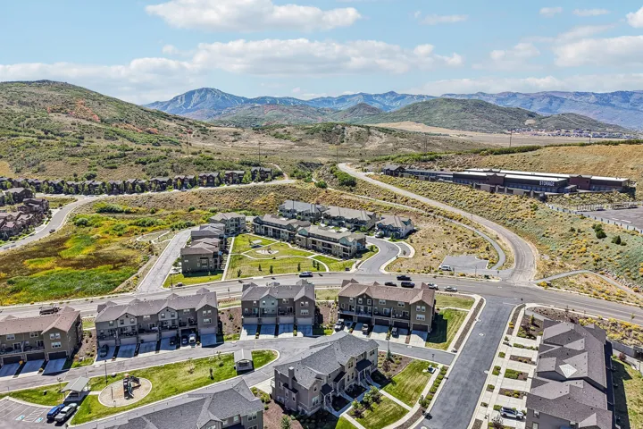 Mountainous terrain, residential developments, winding roadways, and a prominent commercial structure