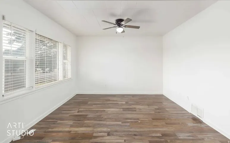 Wood-finish flooring, white walls, and a ceiling fan with integrated lighting