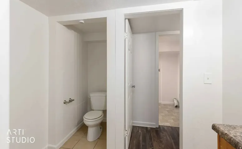 Compact powder room with tile flooring and a standard white toilet