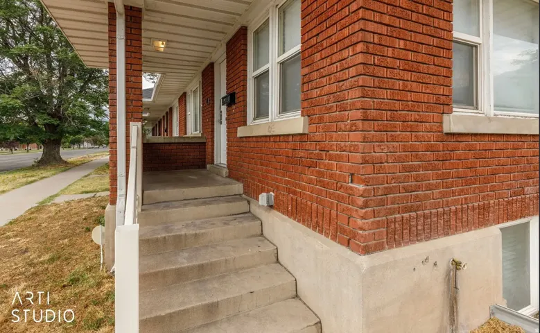 Red brick exterior with white window trim and a covered entryway