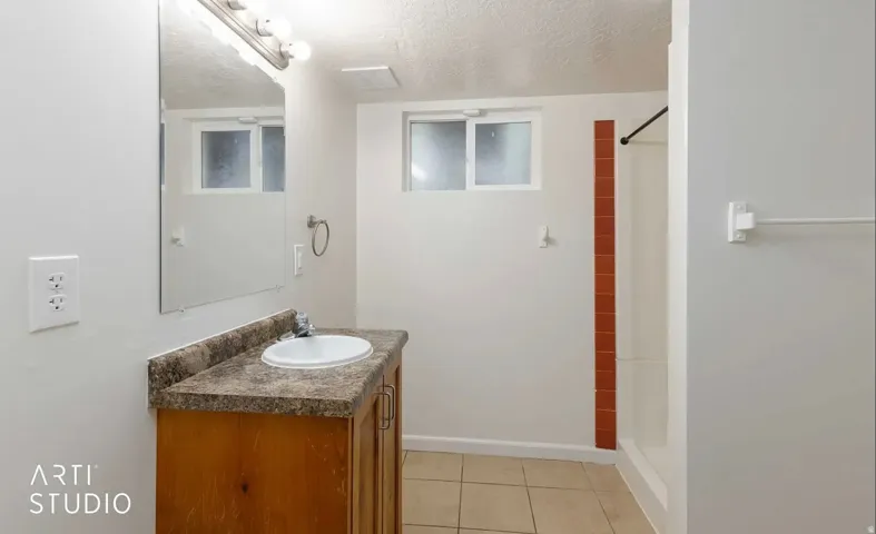 Bathroom featuring a vanity with countertop, integrated sink, and wood-finish cabinetry