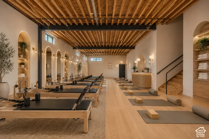 Spacious interior featuring a slatted wood ceiling, light-toned wood-finish flooring, recessed wall niches with accent lighting, and a built-in wood reception desk