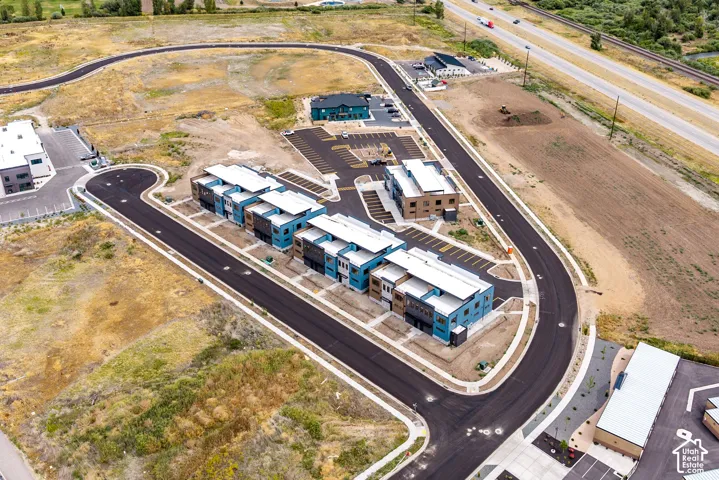 Newly constructed townhomes with contemporary facades, paved roadways, and integrated parking