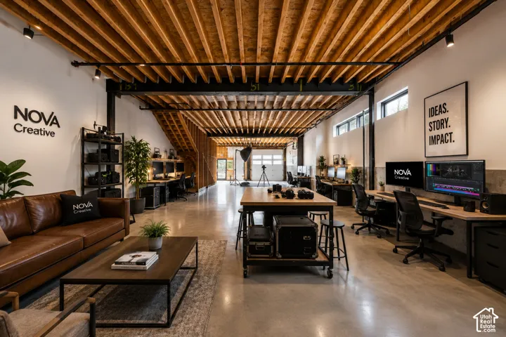 Exposed wood beam ceiling, polished concrete flooring, track lighting, built-in shelving, and transom windows