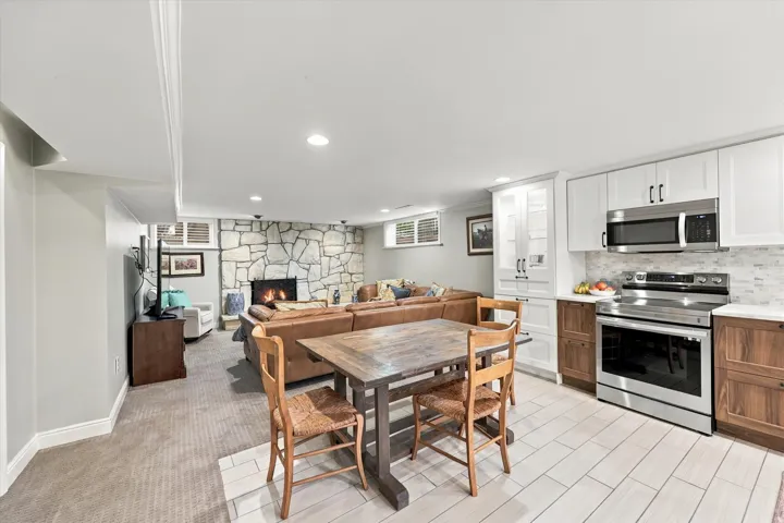 Well-appointed kitchen featuring stainless steel appliances, white upper cabinetry, and wood-finish lower cabinetry