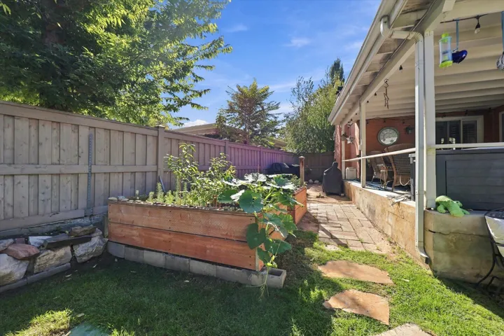Covered patio, raised garden bed, privacy fencing, paver walkway, stone hardscaping