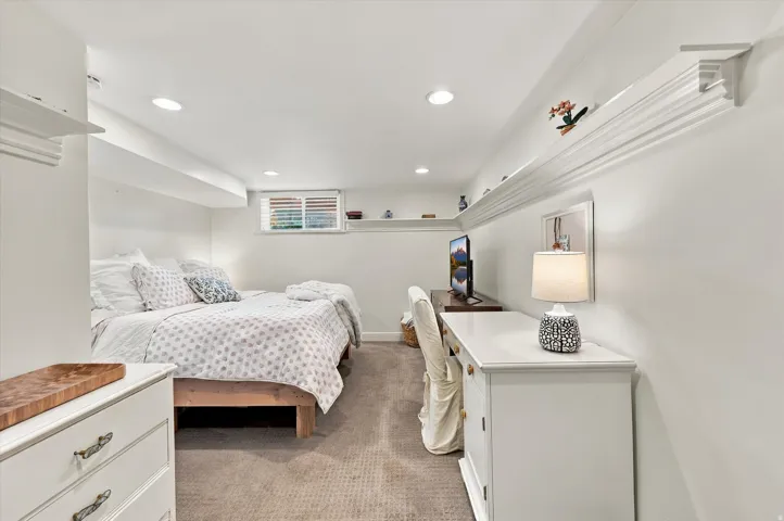 Recessed lighting illuminates the space, complemented by a window with horizontal blinds