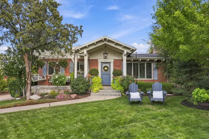 Brick exterior with gabled portico, decorative columns, and a blue entry door