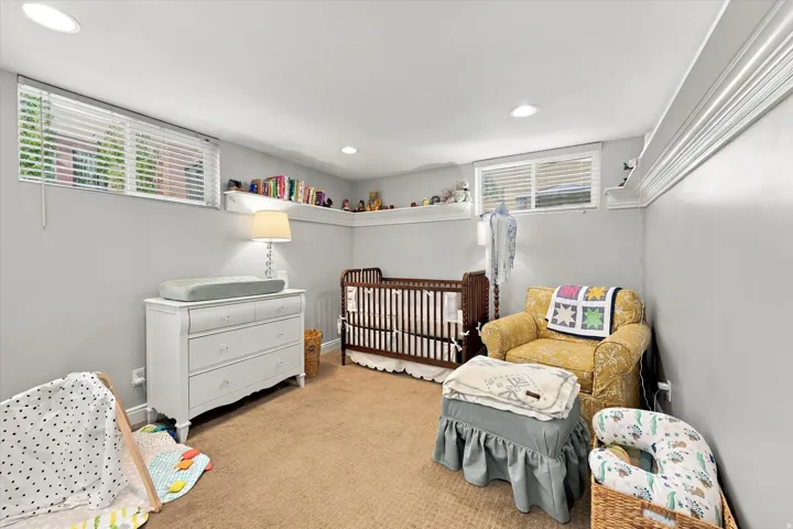 Recessed lighting illuminates neutral-toned carpeting and light gray walls