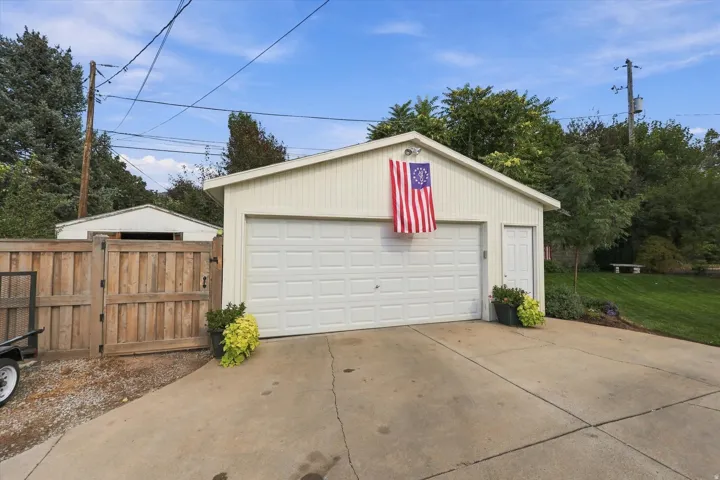 Detached garage with a paneled overhead door and a side entry door