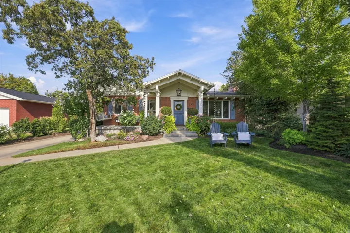 Brick exterior with a gabled portico, column accents, and a vibrant blue entry door