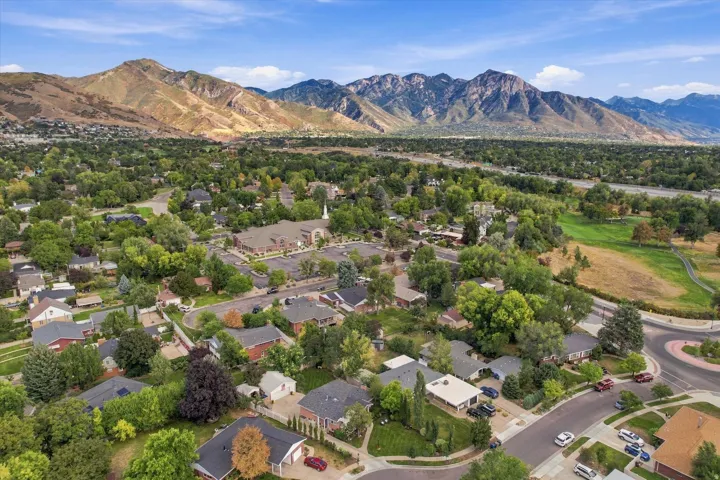 Neighborhood setting with mature trees, established residential properties, and surrounding mountainous landscape