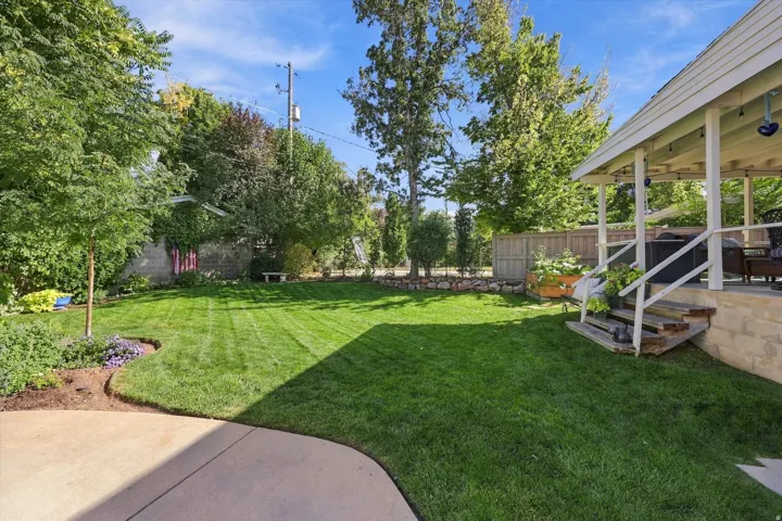 Expansive green lawn with mature trees and perimeter landscaping