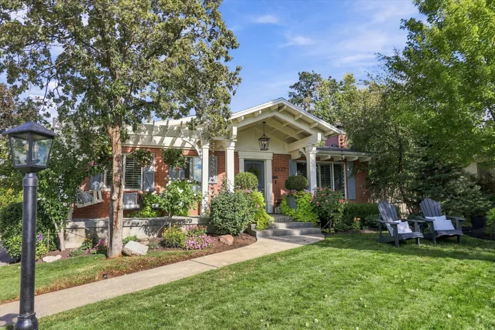 Brick exterior with white pergola and columns, featuring a gabled entry