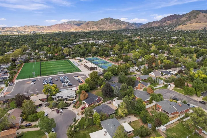 Expansive residential area featuring established homes, mature trees, and mountainous terrain