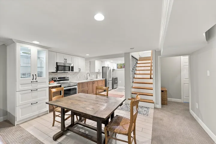 Modern kitchen featuring white shaker cabinetry, stainless steel appliances, and a tile backsplash