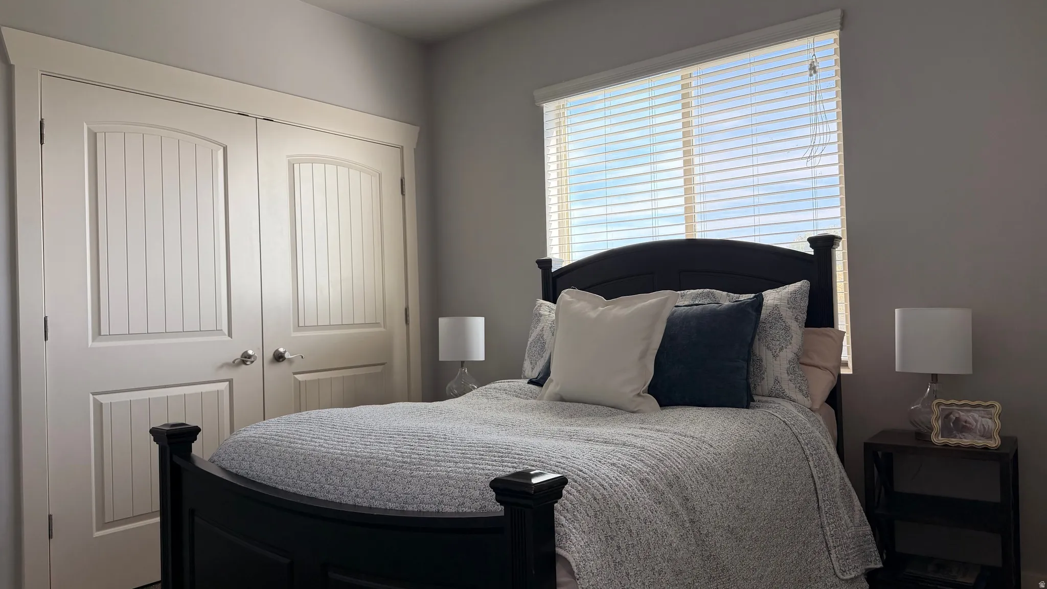 Dual pane window, light gray wall finish, white window blinds, white paneled double doors, satin nickel door hardware
