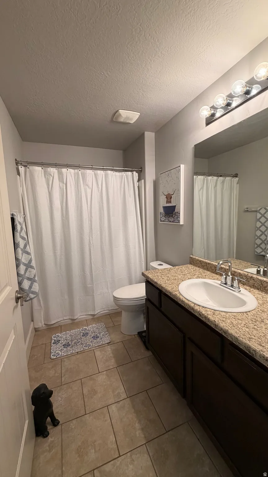 Single vanity with a light-toned countertop, undermount sink, and chrome faucet