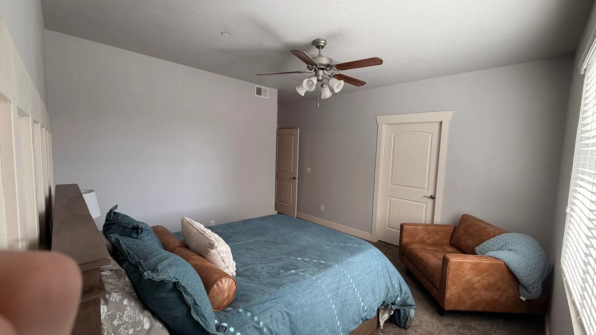 Vaulted ceiling with an attached ceiling fan, neutral wall tones, and carpeted flooring