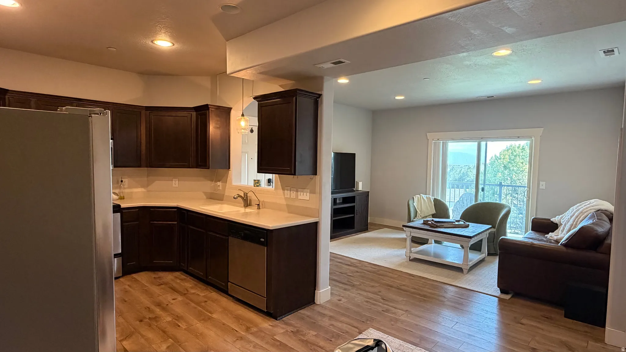 Kitchen featuring dark wood cabinetry, light countertops, and stainless steel appliances