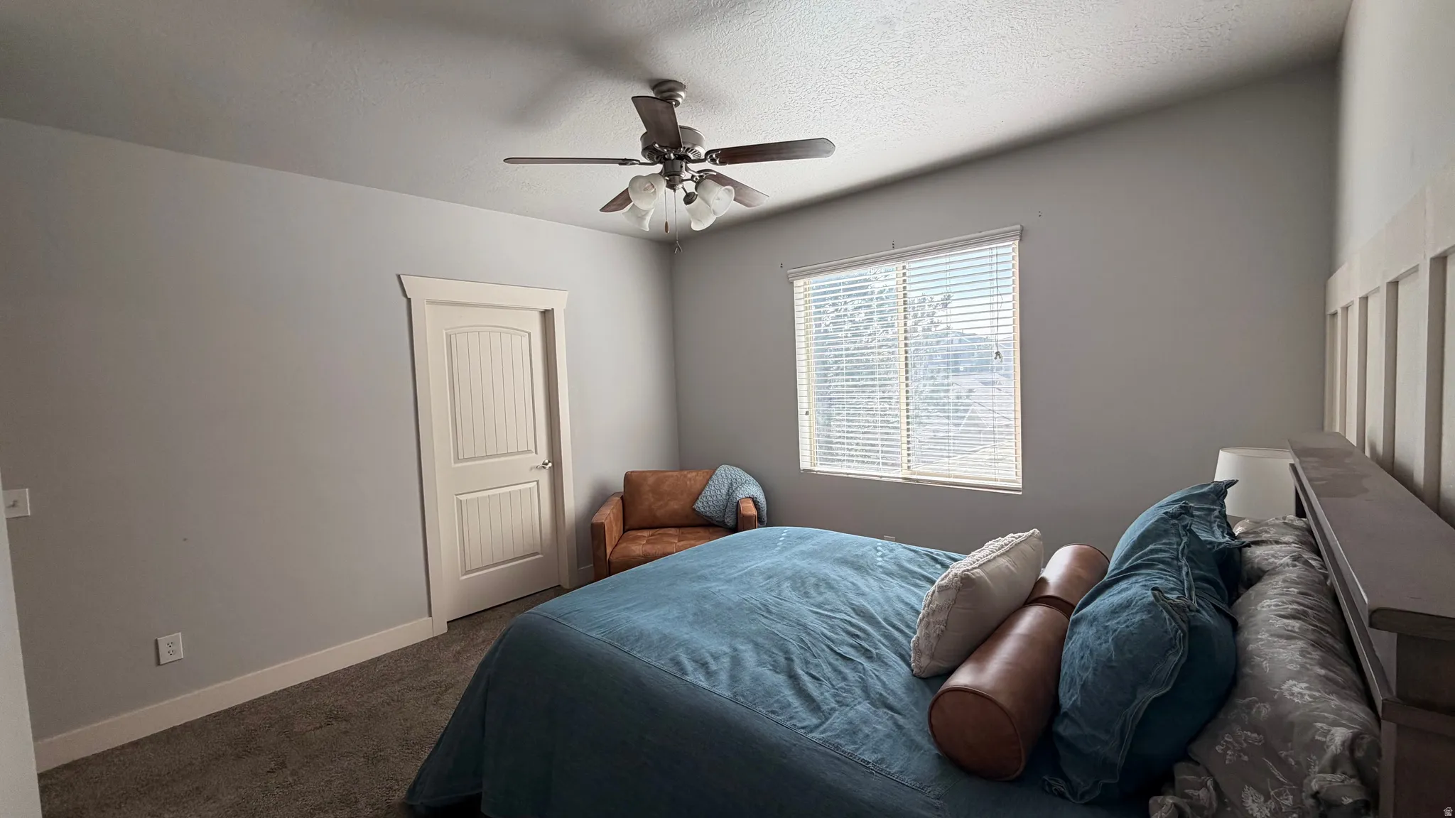 Vaulted ceiling with a ceiling fan, window with blinds, paneled door, and carpeting