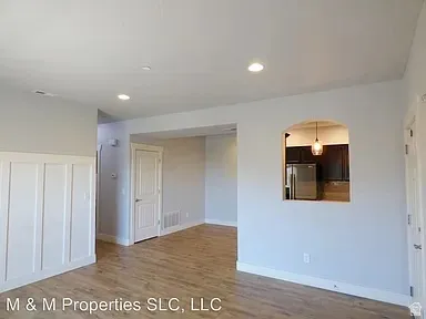 Wood-finish flooring, recessed lighting, and wainscoting detail