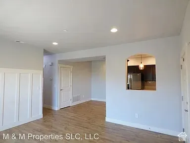 Wood-finish flooring, recessed lighting, and wainscoting detail