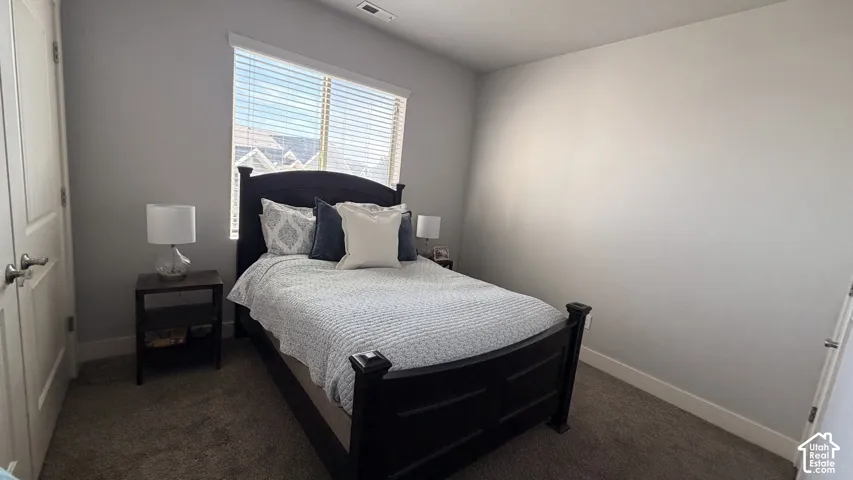 Carpeted room with a window featuring horizontal blinds, and a built-in closet with panel doors