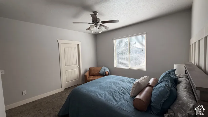 Vaulted ceiling with a ceiling fan, window with blinds, paneled door, and carpeting