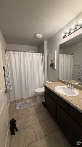 Single vanity with a light-toned countertop, undermount sink, and chrome faucet