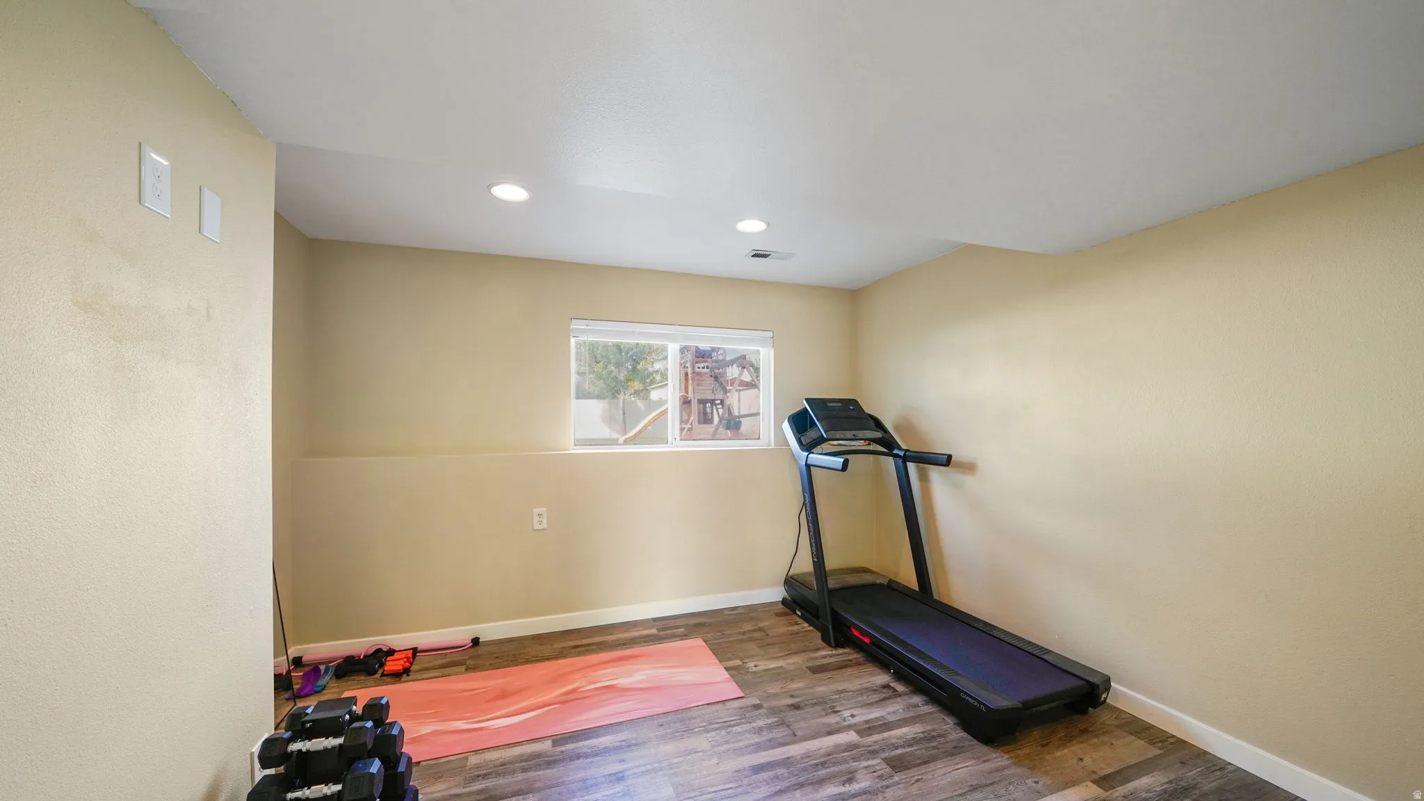 Recessed lighting illuminates wood-finish flooring