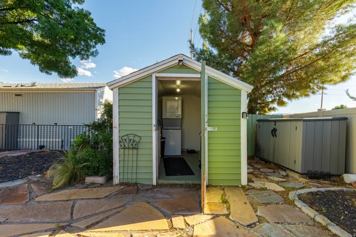 Detached utility shed with painted siding and an interior light fixture