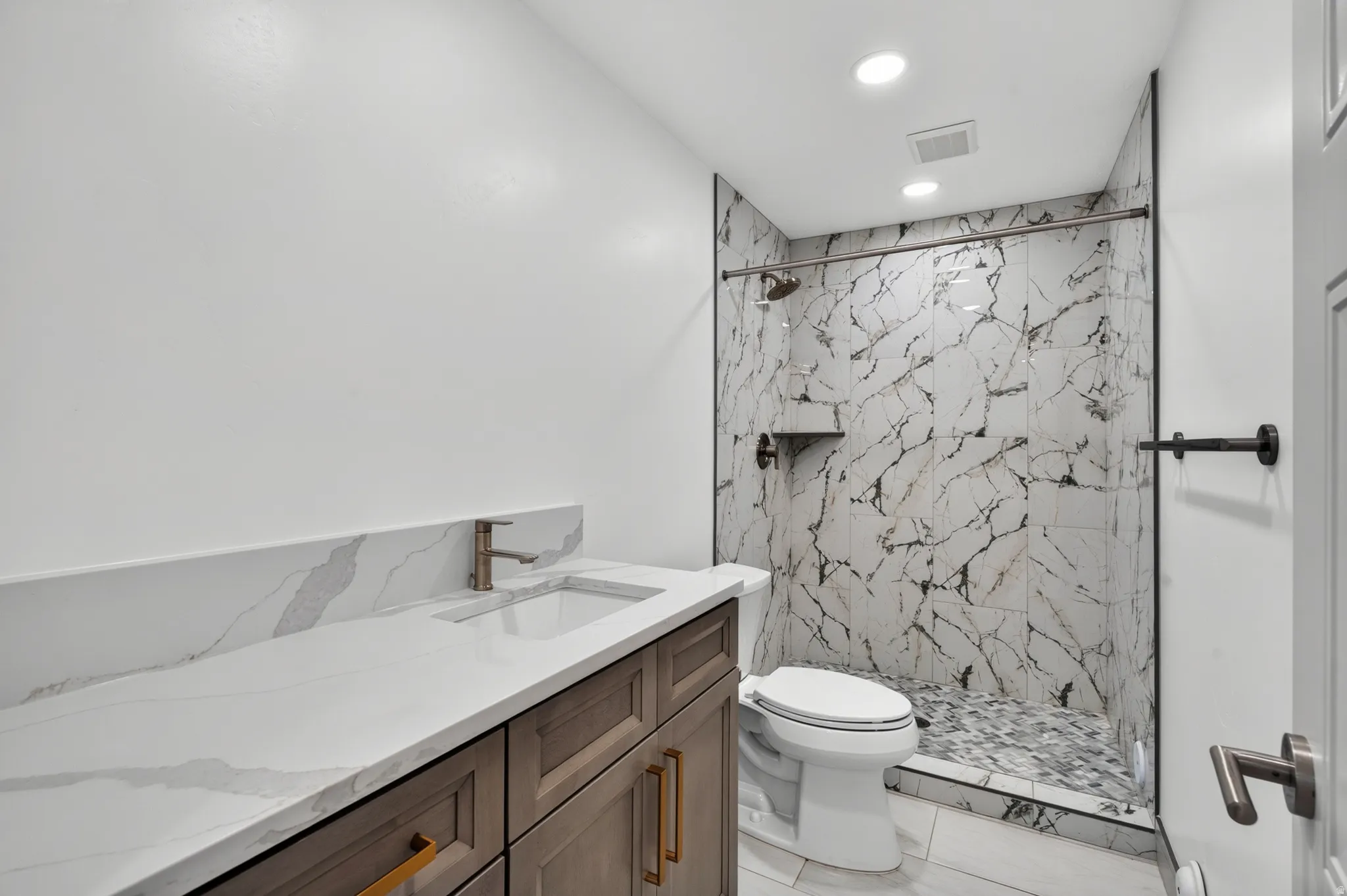 Vanity with integrated sink, stone-finish countertop, and wood-finish cabinetry