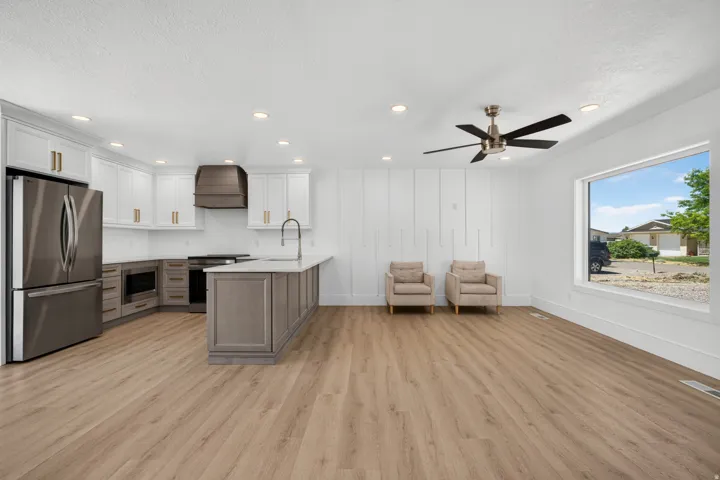 Wood-finish flooring throughout, stainless steel appliances, recessed lighting, and a ceiling fan with light fixture