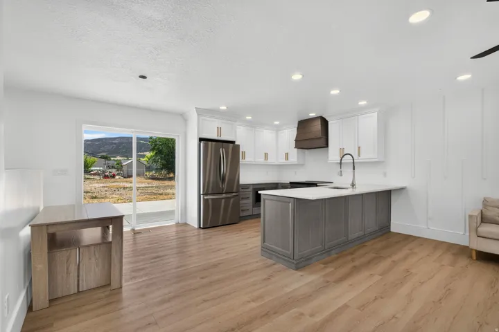 Kitchen with two-tone cabinetry, stainless steel appliances, and a central island with a sink