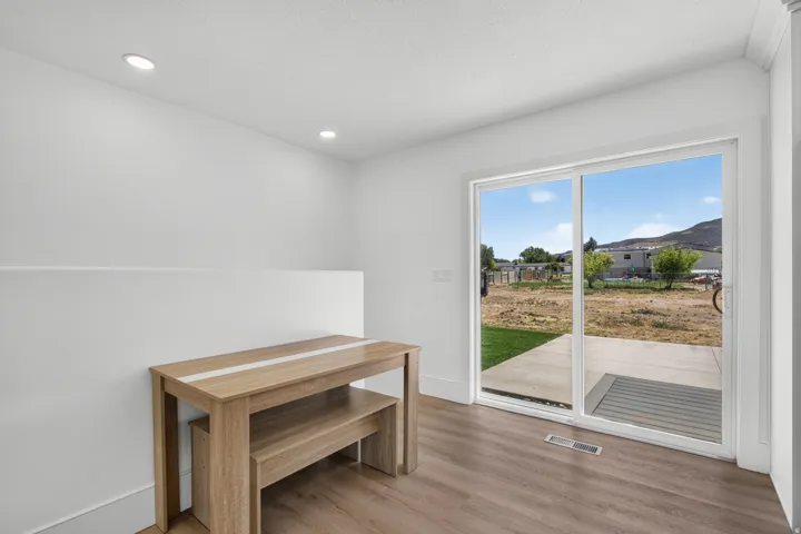 Recessed ceiling lighting, wood-finish flooring, and sliding glass doors with direct outdoor access