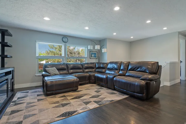 Recessed lighting, wood-finish flooring, and multiple windows with blinds