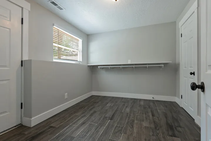 Wood-finish flooring, light grey wall paint, and white trim