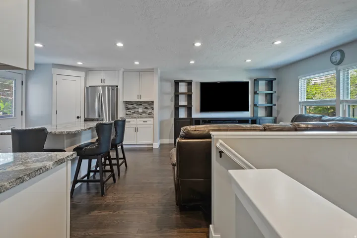 Kitchen features white cabinetry, stainless steel appliances, and a tiled backsplash