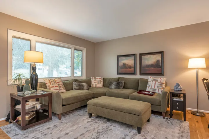 Large windows with white trim, warm neutral wall color, and light wood-finish flooring