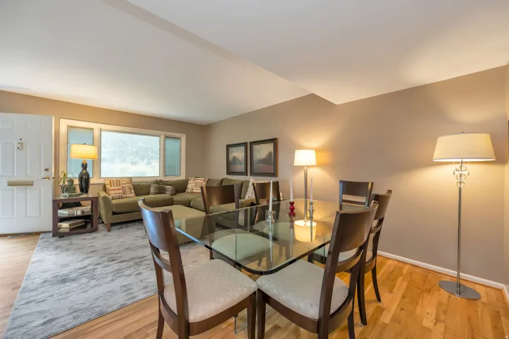 Hardwood flooring extends throughout the space, complemented by a large window and neutral wall tones