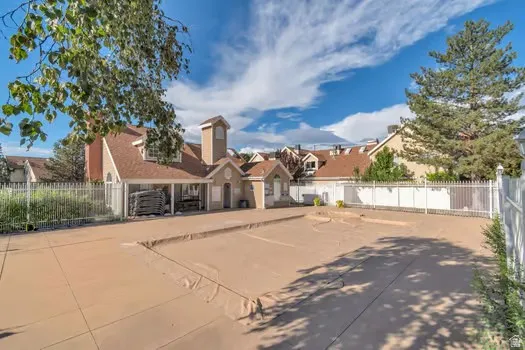 Community building with dormer windows and a central tower, complemented by a covered patio