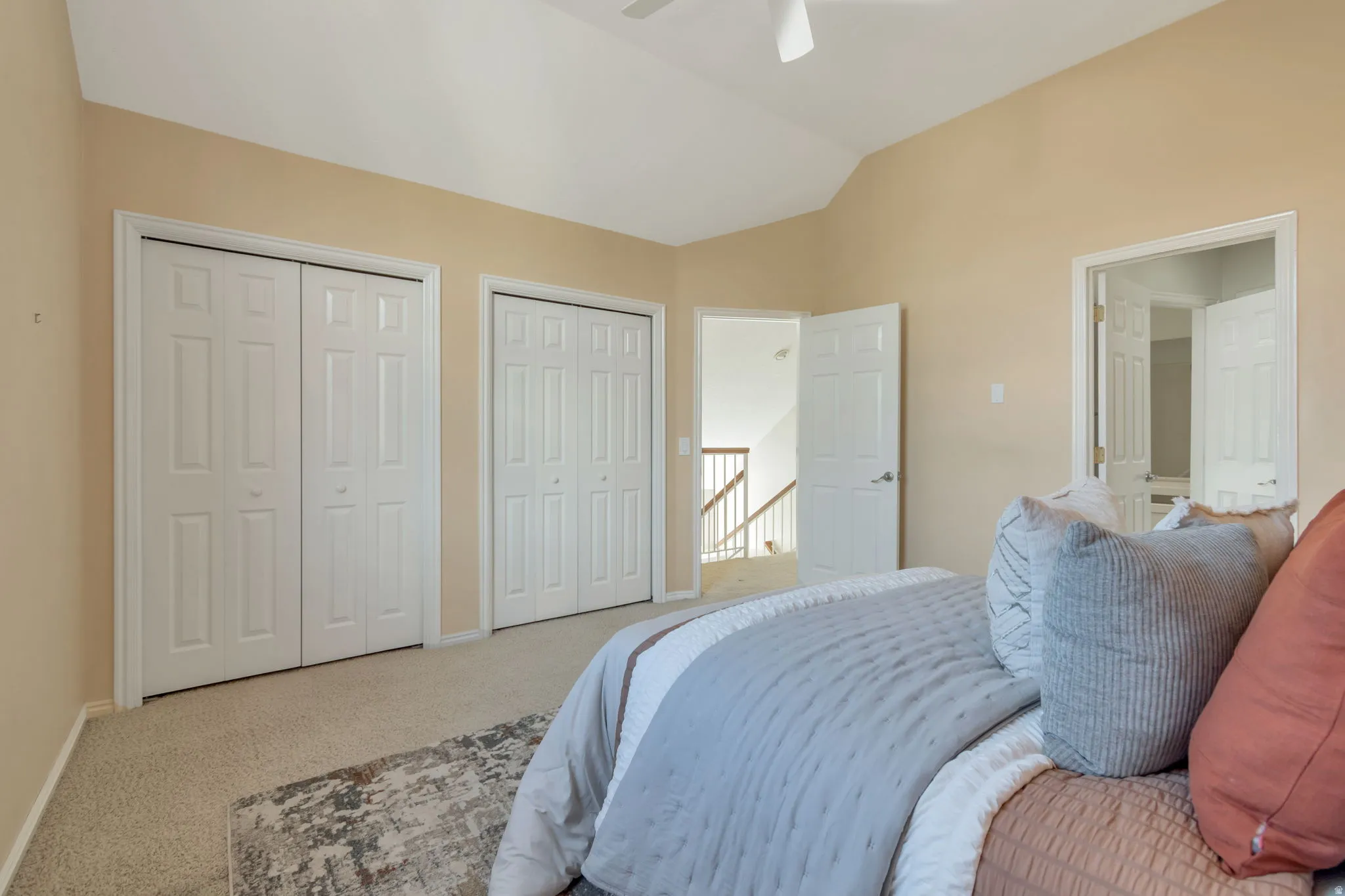 Vaulted ceiling, two sets of bi-fold closet doors, and light-toned carpeting