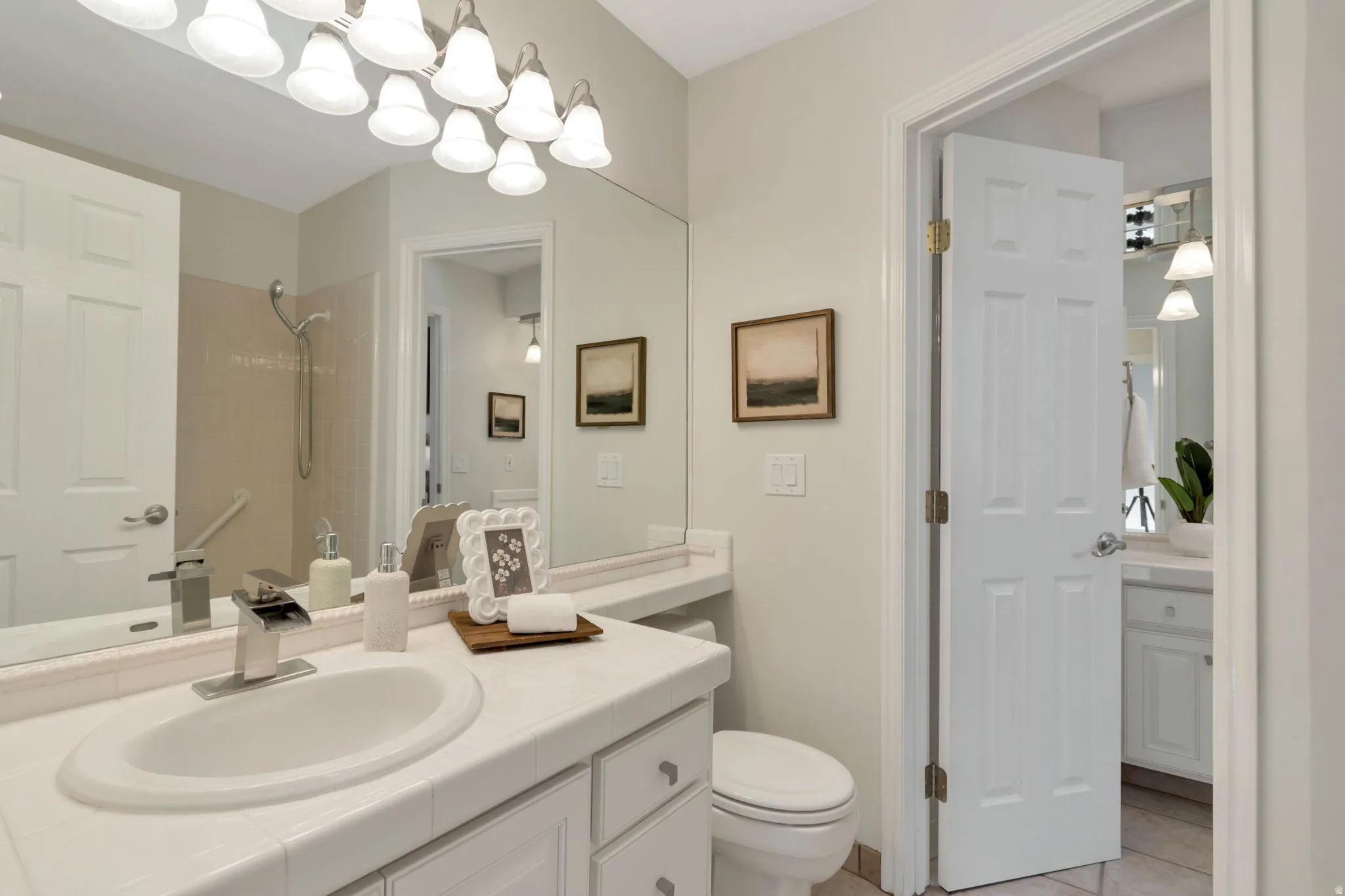 Vanity with a single basin, chrome faucet, and tiled countertop