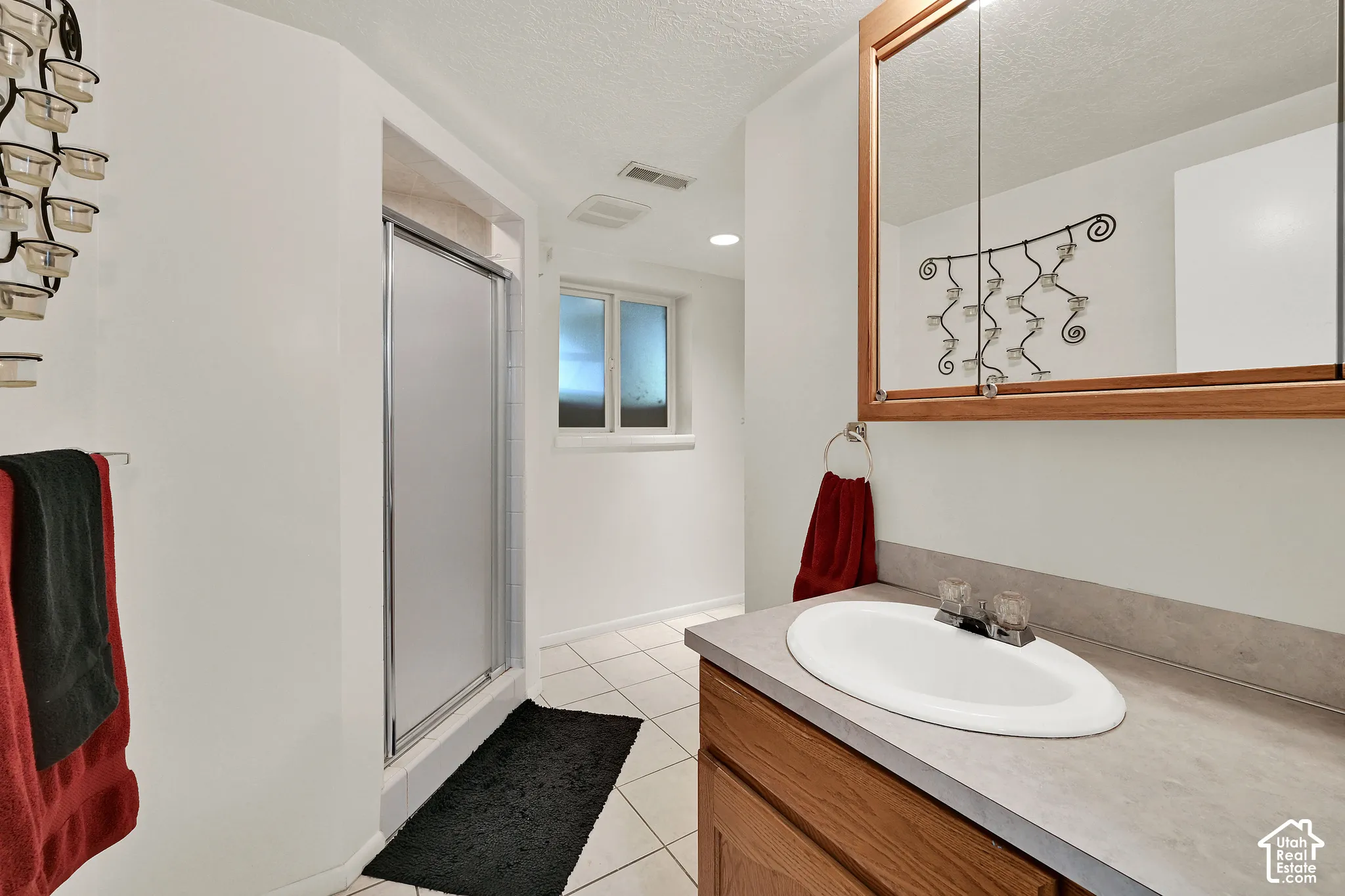 Bathroom with a built-in wood vanity, integrated sink, and an overhead mirrored medicine cabinet
