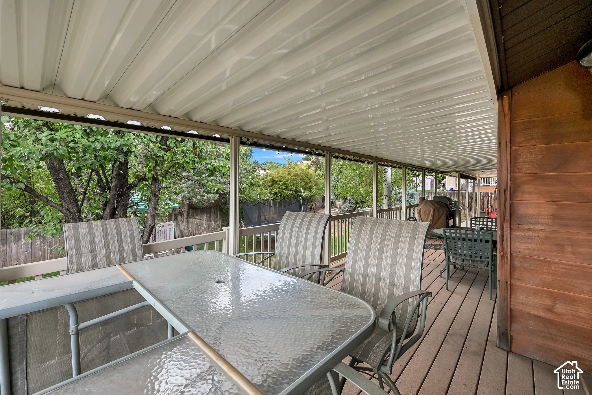 Expansive covered deck featuring wood-finish flooring, a metal awning, and wood railings