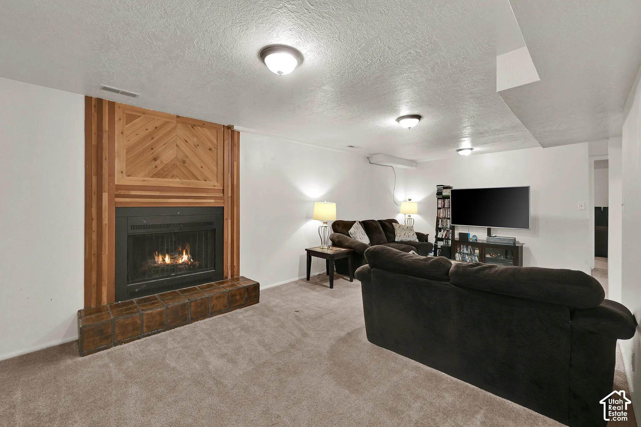 Fireplace featuring a wood surround with a herringbone pattern