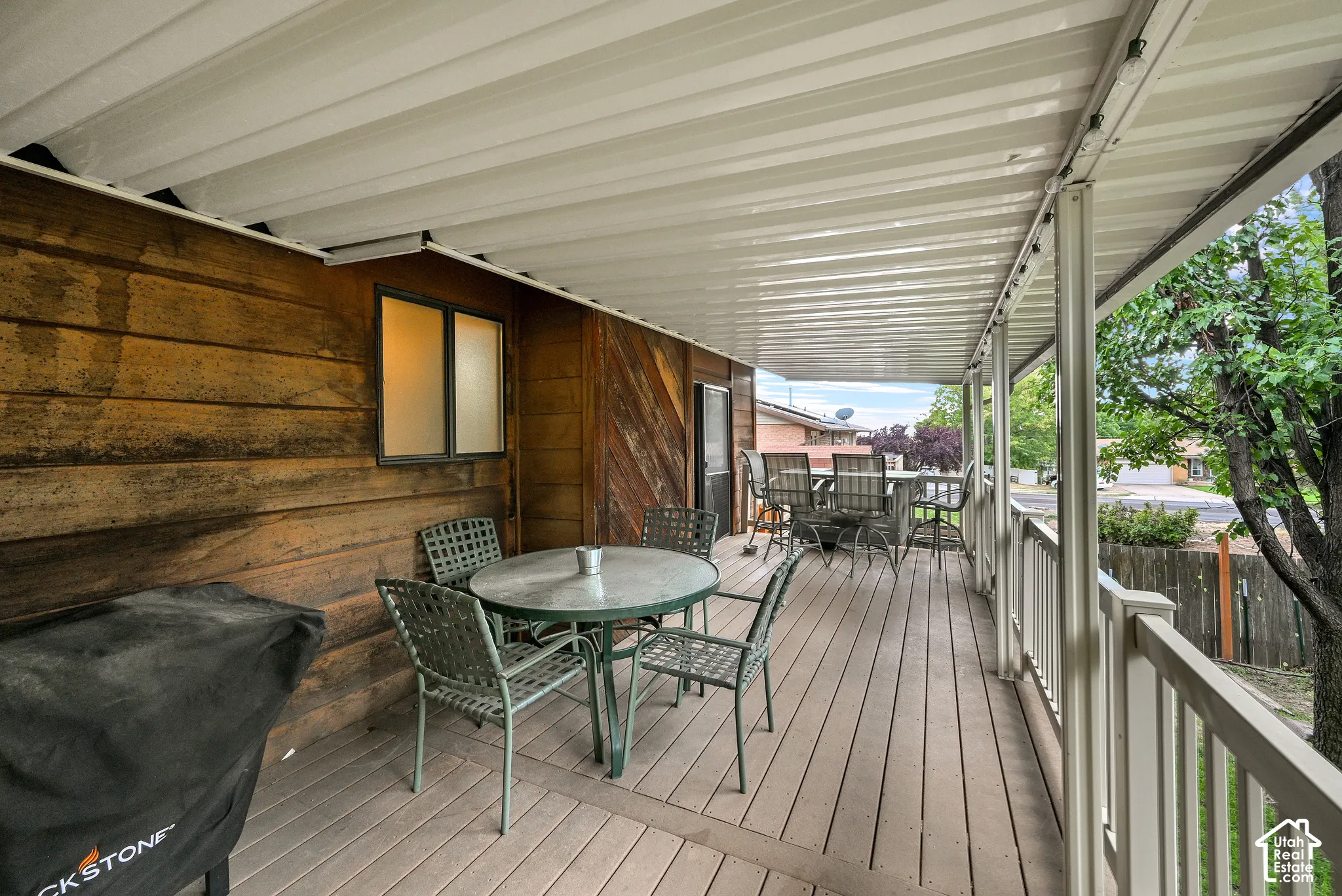 Expansive covered deck featuring wood-finish flooring, a full-length overhead cover, and durable railing