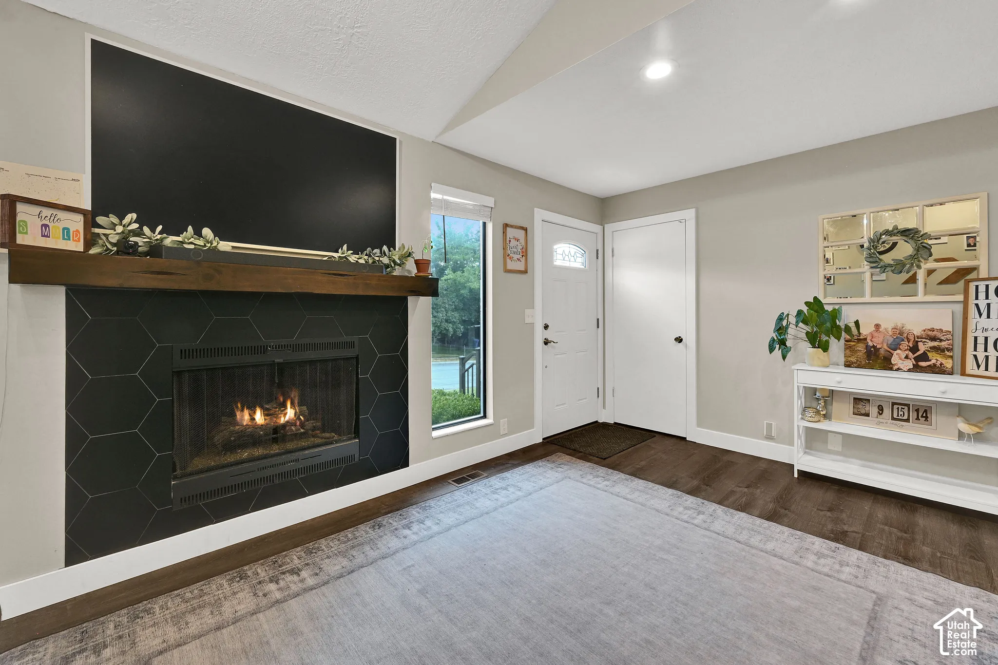 Fireplace featuring a rich wood mantle and hexagonal tile surround