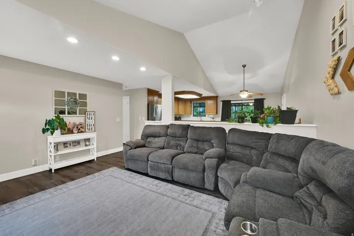 Vaulted ceiling, recessed lighting, wood-finish flooring, kitchen pass-through, and ceiling fan